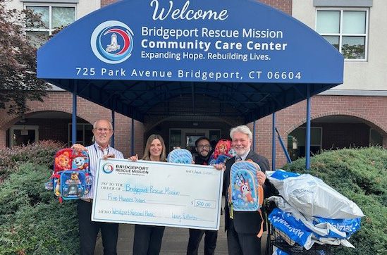 branch manager making back pack donation to Bridgeport Rescue Mission