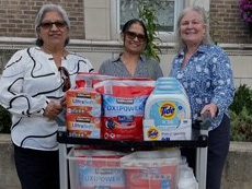picture of our darien staff donating laundry detergent to Darien Human Services.