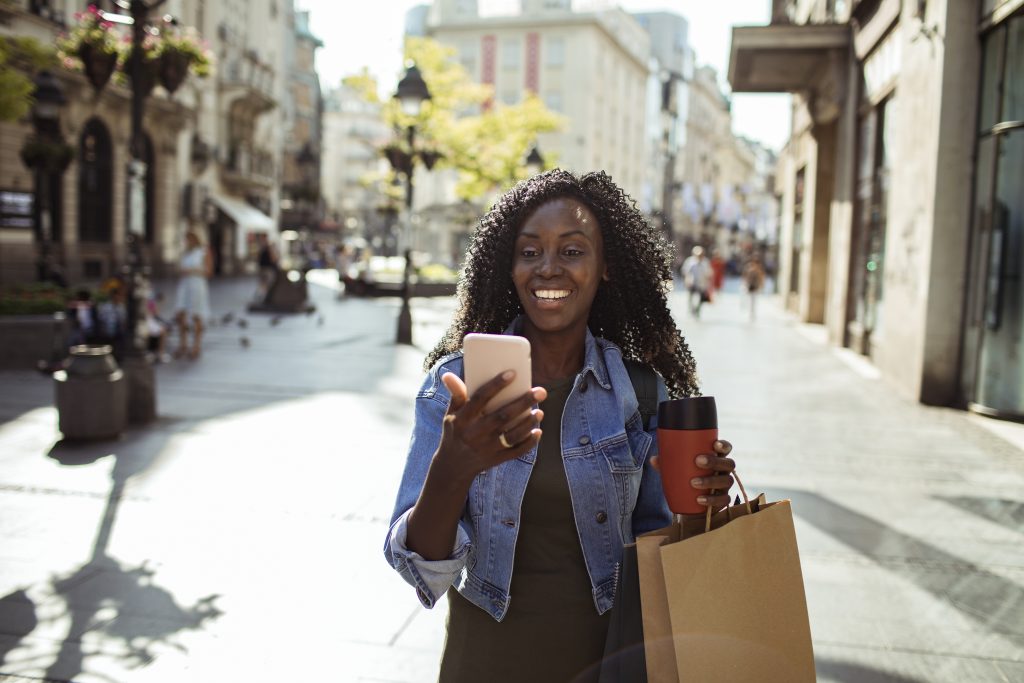 Women using mobile phone while shopping