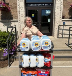 Darien branch manager donating laundry detergent to Darien Human Services